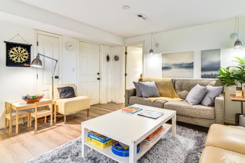 a living room with a couch and a table at 3 Mi to Downtown Portland Lush Flat with Fire Pit in Portland