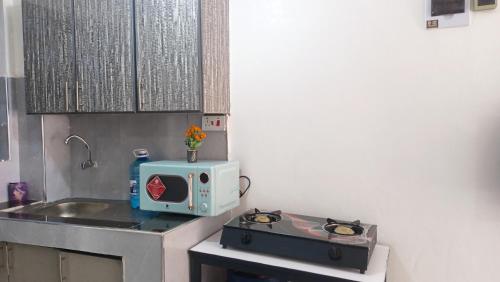 a small kitchen with a stove and a microwave at Franliz Apartments in Nairobi