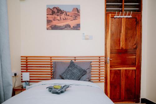 a bedroom with a bed and an open wooden door at Roots and Waves in Zanzibar City