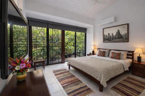 a bedroom with a large bed and large windows at 519@jamtree in Colombo