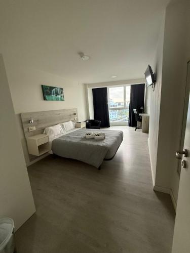 a hotel room with a bed and a large window at Pensión La Intermodal in Santiago de Compostela