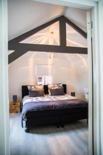 a bedroom with a large bed with a large ceiling at B&B Ons Dijkhuisje in Schuddebeurs