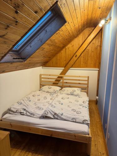 a bed in a room with a wooden ceiling at L&B Home in Pravonín