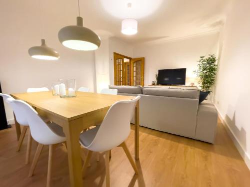 a dining room with a table and a couch at Apartment near Sintra and Lisbon in Belas