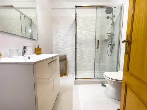 a bathroom with a shower and a sink and a toilet at Apartment near Sintra and Lisbon in Belas