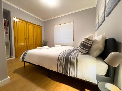 a bedroom with a large white bed and a window at Apartment near Sintra and Lisbon in Belas