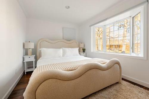 a white bedroom with a large bed and a window at Norwalk Retreat in Norwalk