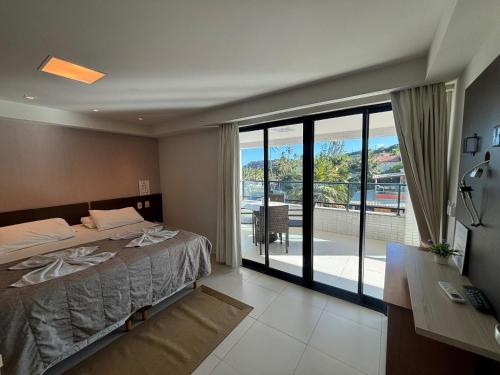 a bedroom with a bed and a view of a patio at Flat Gold Sea View - Tabatinga Beach in Conde