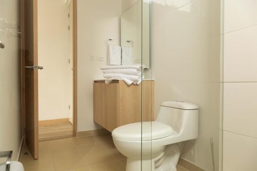 a bathroom with a toilet and a glass shower at Hotel Estar in Manizales