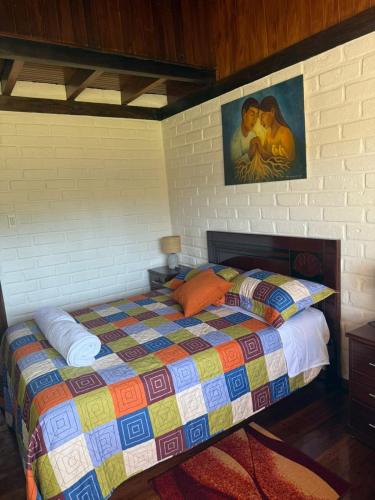 a bedroom with a bed with a colorful quilt at Casa acogedora y espaciosa in Huamboya