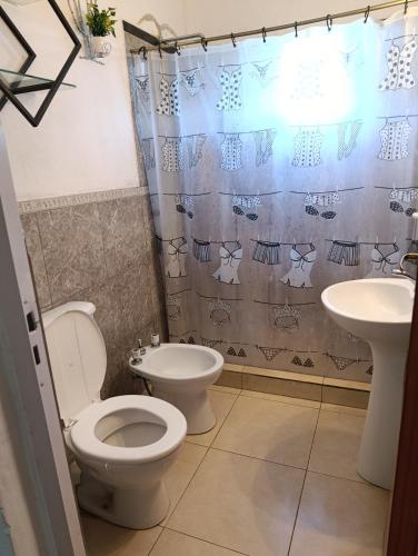a bathroom with a toilet and a sink at La Morada de sus Sueños Caeiro in Bialet Massé