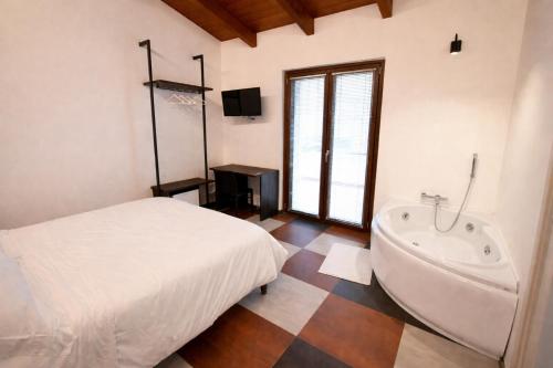 a bedroom with a bed and a bath tub at IL CAMBUSIERE nature relais in Ortona