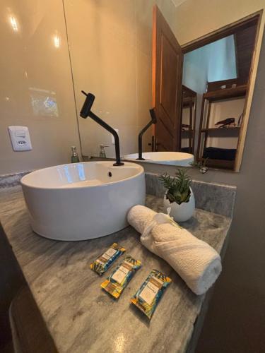 a bathroom with a large tub and a sink at Casa Recanto das arvores in Itacaré