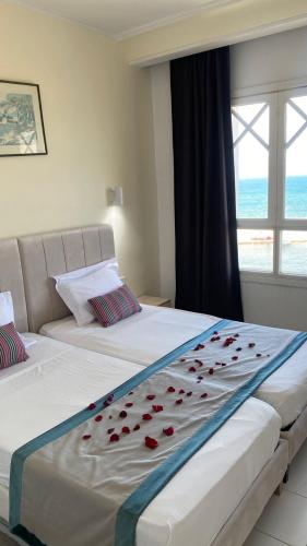 a bedroom with two beds with roses on the sheets at Hotel Mezri in Monastir