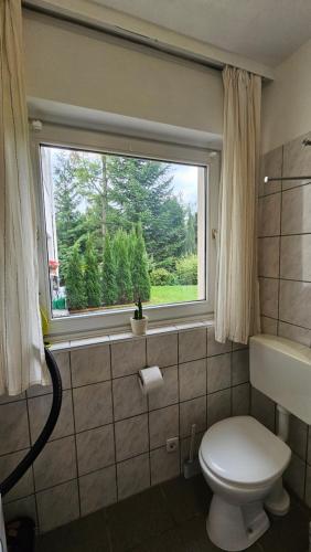 a bathroom with a toilet and a window at Holiday Everyday in Hemer in Hemer