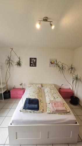 a bed in a room with two potted plants at Holiday Everyday in Hemer in Hemer