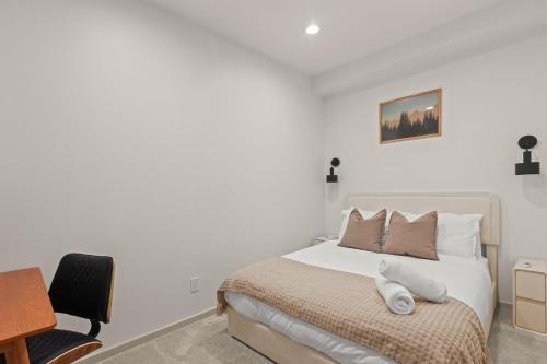 a white bedroom with a bed and a desk at Seattle Waterfront Condo - Walk Up Steps to Pike Place in Seattle