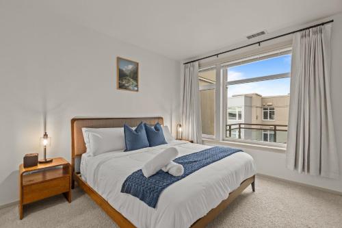 a bedroom with a bed with a large window at Seattle Waterfront Condo - Walk Up Steps to Pike Place in Seattle