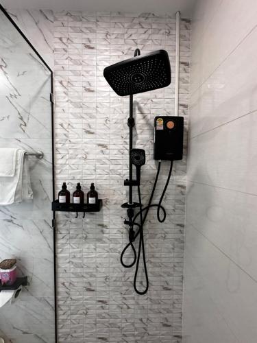 a shower in a bathroom with a black shower head at Patong Relax Home in Patong Beach