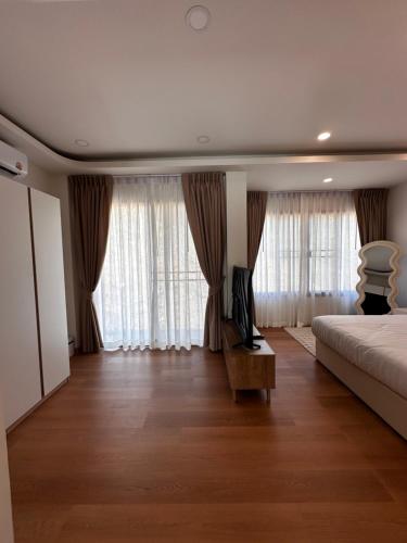 a bedroom with a bed and a couch and windows at Patong Relax Home in Patong Beach