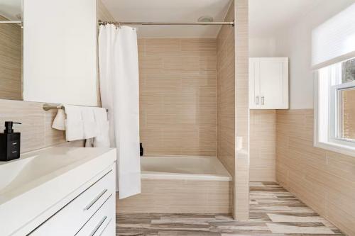 a white bathroom with a tub and a sink at Norwalk Retreat in Norwalk