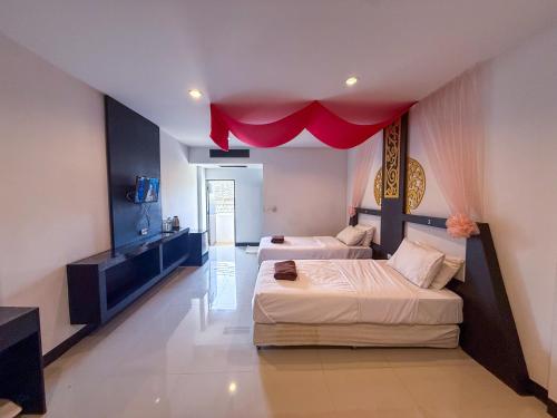 a bedroom with two beds and a red ceiling at POR SAHA Hotel Ramkhamhaeng 100 in Bang Kapi