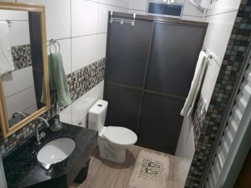 a bathroom with a toilet and a sink and a shower at Studio Carimã Foz in Foz do Iguaçu