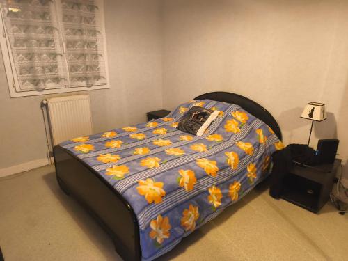 a bedroom with a bed with orange flowers on it at Pavillon in Saint-Berthevin-sur-Vicoin