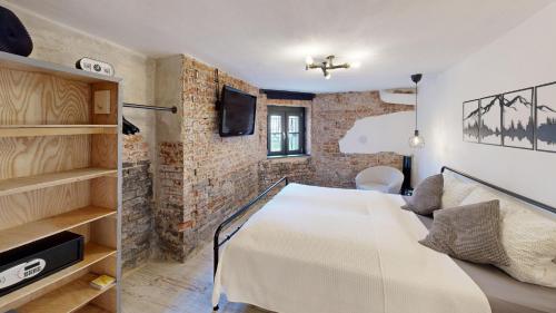 a bedroom with a white bed and a brick wall at Apartment 22 - zentrumsnah - Parkplatz in Coburg
