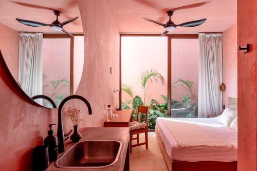 a bathroom with a sink and a bedroom with a bed at Amplitude Coliving in Brisas de Zicatela