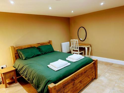 a bedroom with a bed with green sheets and a mirror at Ground floor, Very central, 2 Bed - Cobbles Apartment in Buxton