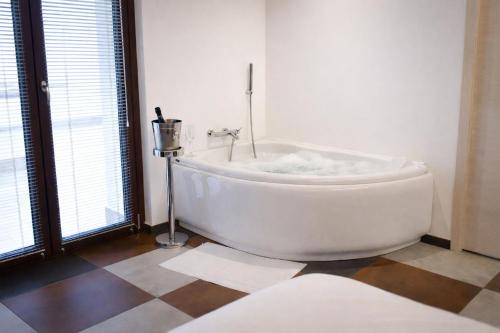 a white bath tub in a room with windows at IL CAMBUSIERE nature relais in Ortona