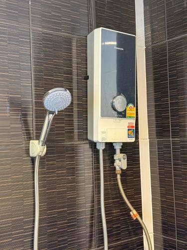 a bathroom with a shower and a soap dispenser at POR SAHA Hotel Ramkhamhaeng 100 in Bang Kapi