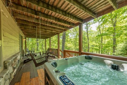 a jacuzzi tub on the porch of a cabin at Happy Times by Railey Vacations in Swanton