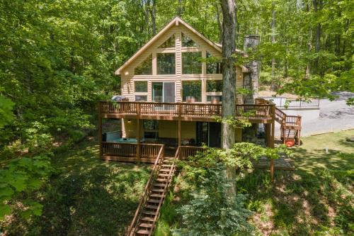 a house in the woods with a wrap around deck at Happy Times by Railey Vacations in Swanton