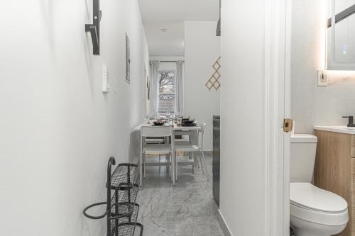 a white bathroom with a table and a toilet at Modern Comfort 2BR with Washer & Dryer Near Subway & LGA in Corona