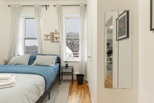 a bedroom with a bed and two windows at Modern Comfort 2BR with Washer & Dryer Near Subway & LGA in Corona