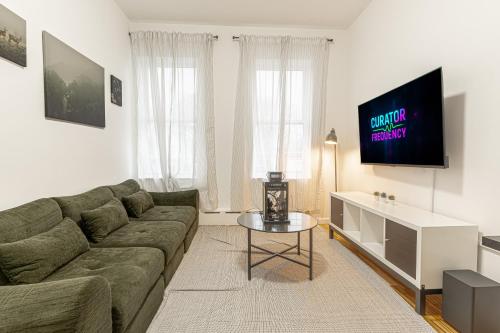 a living room with a couch and a tv at Modern Comfort 2BR with Washer & Dryer Near Subway & LGA in Corona