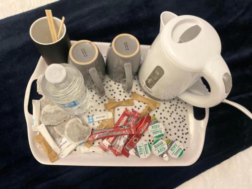 a tray with a tea pot and a lot of junk at Cozy en-suite Room-city centre in Wolverhampton
