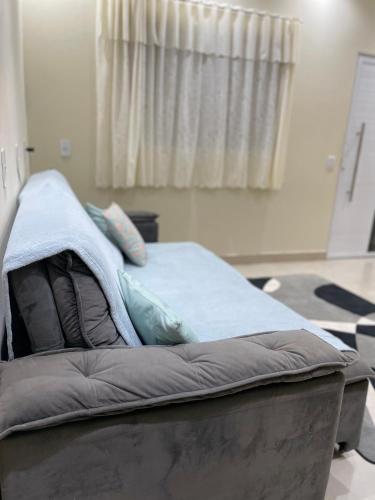 a bed with a blanket on it in a room at Recanto dos Ipês a 4 min do Moinho in Holambra