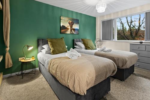 two beds in a room with green walls at Forest View- Oasis Mural -Didsbury Zen Sleeps 10 in Manchester