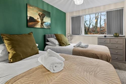 two beds in a room with green walls at Forest View- Oasis Mural -Didsbury Zen Sleeps 10 in Manchester