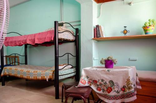 a room with two bunk beds and a table with at Hospedaje Jazmin Cosquín in Cosquín