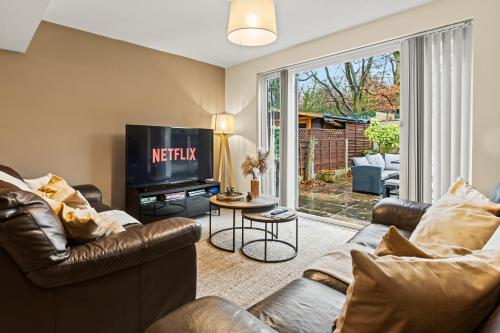 a living room with two couches and a television at Forest View- Oasis Mural -Didsbury Zen Sleeps 10 in Manchester