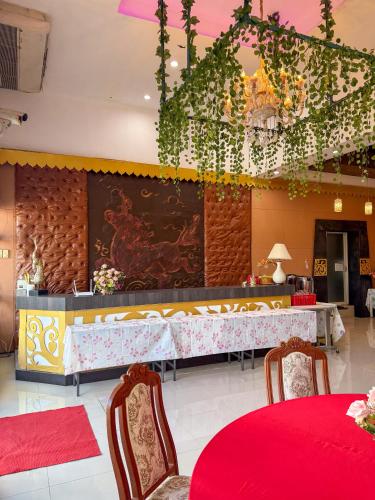 a restaurant with red tables and chairs and a buffet at POR SAHA Hotel Ramkhamhaeng 100 in Bang Kapi