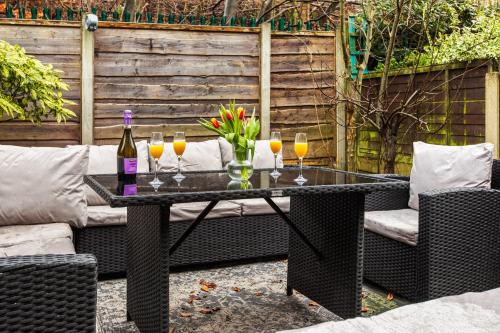 a table with glasses of wine and flowers on it at Forest View- Oasis Mural -Didsbury Zen Sleeps 10 in Manchester