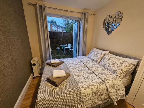 a bedroom with a bed with two towels on it at Cozy Central One Bedroom Flat in Reading