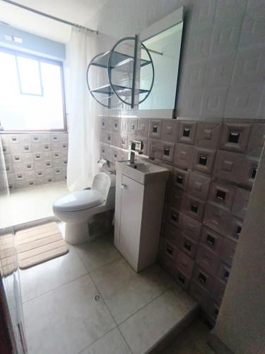 a bathroom with a toilet and a sink and a mirror at Residencial SKD in Puno