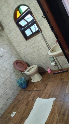 a bathroom with a toilet and a sink and a window at Recanto do mar in Caraguatatuba
