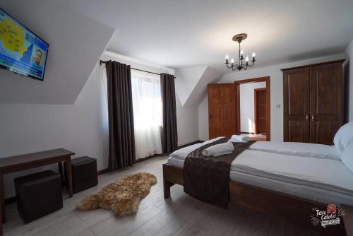 a bedroom with a bed and a dog laying on the floor at Pensiunea Merişor in Răchiţele